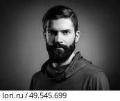Portrait of handsome man with beard and mustache. Close-up image of serious brutal bearded man on dark background. Black and white photography. Стоковое фото, агентство Ingram Publishing / Фотобанк Лори