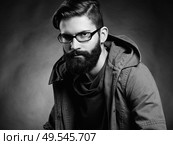 Portrait of handsome man with beard and mustache. Close-up image of serious brutal bearded man on dark background. Man with glasses. Black and white photography. Стоковое фото, агентство Ingram Publishing / Фотобанк Лори