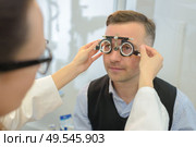 man wearing phoropter for eye test. Стоковое фото, агентство Ingram Publishing / Фотобанк Лори