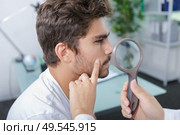 close-up of doctors hands checking mans moles. Стоковое фото, агентство Ingram Publishing / Фотобанк Лори
