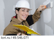 female plasterer painter doing a wall renovation. Стоковое фото, агентство Ingram Publishing / Фотобанк Лори