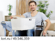 disabled man in wheelchair doing laundry. Стоковое фото, агентство Ingram Publishing / Фотобанк Лори
