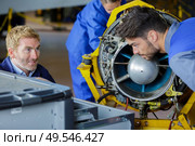 engineering teacher checking airplane engines with his students. Стоковое фото, агентство Ingram Publishing / Фотобанк Лори