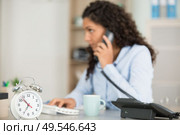 woman working in an office holding a clock. Стоковое фото, агентство Ingram Publishing / Фотобанк Лори