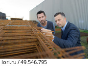 worker and manager inspecting concrete reinforcement pieces at yard. Стоковое фото, агентство Ingram Publishing / Фотобанк Лори