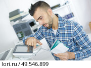 young attractive worker man working using printmaking device. Стоковое фото, агентство Ingram Publishing / Фотобанк Лори