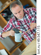 young plumber using blowtorch for soldering copper fittings. Стоковое фото, агентство Ingram Publishing / Фотобанк Лори