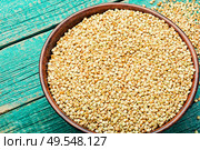 Uncooked green buckwheat on wooden background,vegan food.Dry buckwheat in white ceramic bowl. Green buckwheat on wooden table. Стоковое фото, агентство Ingram Publishing / Фотобанк Лори