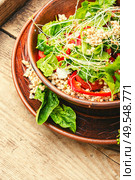 Dietary salad with sprouted green buckwheat, celery, tomato and microgreens on wooden table. Fresh salad in plate. Стоковое фото, агентство Ingram Publishing / Фотобанк Лори