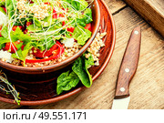 Dietary salad with sprouted green buckwheat, celery, tomato and microgreens on wooden table. Fresh salad in plate. Стоковое фото, агентство Ingram Publishing / Фотобанк Лори