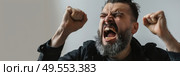 A man with a beard is shown screaming in this photo. Стоковое AI-изображение, AI-художник Данила Большаков / Фотобанк Лори