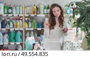 Selective young female customer choosing convenient nail polish in retail store. Стоковое видео, видеограф Яков Филимонов / Фотобанк Лори