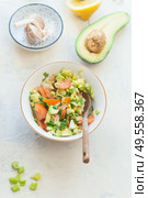 Tasty fresh avocado tomato salsa salad on white kitchen table background, top view. Healthy food.  Vegetarian lunch or snack. Стоковое фото, агентство Ingram Publishing / Фотобанк Лори