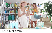 Young woman is preparing for a hot summer in Europe and buys sunscreen to protect skin from the sun's rays. Customer chooses tanning products and cream with SPF in a supermarket. Стоковое видео, видеограф Яков Филимонов / Фотобанк Лори