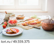 Delicious strawberry rhubarb strudel cake on sunny kitchen table with ingredients at window. Homemade seasonal cuisine. Стоковое фото, агентство Ingram Publishing / Фотобанк Лори