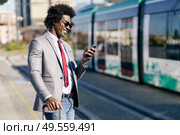 Smiling Black Businessman waiting for the next train. Man with afro hair commuting.. Smiling Black Businessman waiting for the next train. Стоковое фото, агентство Ingram Publishing / Фотобанк Лори