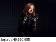 young red-haired girl in a white dress and a black leather rocker jacket sings emotionally into the microphone. Стоковое фото, агентство Ingram Publishing / Фотобанк Лори