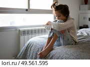 Nine-year-old girl sitting in bed at home bored by confinement. Nine-year-old girl sitting in bed bored by confinement. Стоковое фото, агентство Ingram Publishing / Фотобанк Лори
