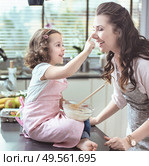 Mother adn daughter whisking dough in the glass bowl. Стоковое фото, агентство Ingram Publishing / Фотобанк Лори