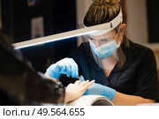 Aesthetician doing the manicure, filing the nails with a file to his client in a beauty center. Business and beauty concepts. Aesthetician doing the manicure, filing the nails with a file to his client in a beauty center. Стоковое фото, агентство Ingram Publishing / Фотобанк Лори