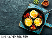 Fried eggs with cherry tomatoes in frying pan.Fried eggs in cast iron frying pan. Scrambled eggs on frying pan. Стоковое фото, агентство Ingram Publishing / Фотобанк Лори