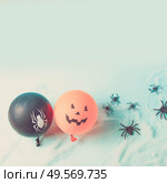 Halloween scene with to scary balloons on blue background, retro toned. Halloween scene with balloons. Стоковое фото, агентство Ingram Publishing / Фотобанк Лори