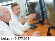 two male medical staff consulting computer screens. Стоковое фото, агентство Ingram Publishing / Фотобанк Лори
