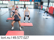 people working out out squats at gym club. Стоковое фото, агентство Ingram Publishing / Фотобанк Лори