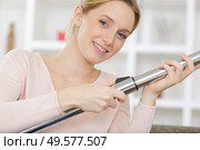 young woman hoovering carpet at home. Стоковое фото, агентство Ingram Publishing / Фотобанк Лори