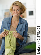 lady sat on sofa folding laundered clothes. Стоковое фото, агентство Ingram Publishing / Фотобанк Лори