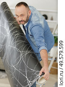 man with vr glasses gluing wallpaper. Стоковое фото, агентство Ingram Publishing / Фотобанк Лори