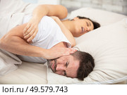 frustrated man covers ears with pillow cannot fall asleep. Стоковое фото, агентство Ingram Publishing / Фотобанк Лори