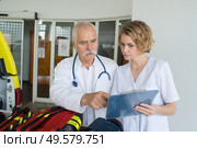 paramedics by ambulance looking at clipboard. Стоковое фото, агентство Ingram Publishing / Фотобанк Лори