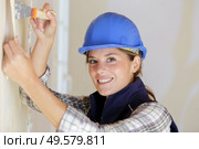 portrait of female builder stripping wallpaper. Стоковое фото, агентство Ingram Publishing / Фотобанк Лори