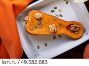 baked pumpkin with walnuts and seeds,   served at wooden brown table with  orange  napkin. flat lay. healthy life concept. Стоковое фото, агентство Ingram Publishing / Фотобанк Лори