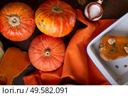 baked pumpkin with walnuts and seeds,  coconut milk  served at wooden brown table with ripe orange  pumkins. flat lay. healthy life concept. Стоковое фото, агентство Ingram Publishing / Фотобанк Лори