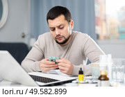 Young man searching internet on laptop for information about medicines. Стоковое фото, фотограф Яков Филимонов / Фотобанк Лори