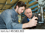 apprentice factory worker learning the trade with mentor. Стоковое фото, агентство Ingram Publishing / Фотобанк Лори
