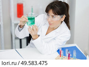 female worker mixing blue liquid in a beaker. Стоковое фото, агентство Ingram Publishing / Фотобанк Лори