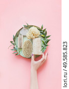 Women hand with eco friendly beauty and skin care bathroom accessories: natural sisal brush, wooden comb, soap, reusable make up removal pads. Zero waste. Top view. Natural and pastel colors. Стоковое фото, агентство Ingram Publishing / Фотобанк Лори