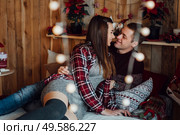 a guy and a girl celebrate the new year togetherin a warm atmosphere and give each other gifts. Стоковое фото, агентство Ingram Publishing / Фотобанк Лори