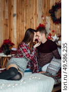a guy and a girl celebrate the new year togetherin a warm atmosphere and give each other gifts. Стоковое фото, агентство Ingram Publishing / Фотобанк Лори
