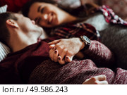 a guy and a girl celebrate the new year togetherin a warm atmosphere and give each other gifts. Стоковое фото, агентство Ingram Publishing / Фотобанк Лори