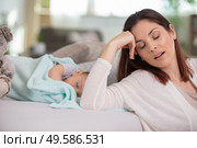 tired mother with baby boy at home. Стоковое фото, агентство Ingram Publishing / Фотобанк Лори