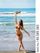 Young woman in swimwear and sunhat, enjoying the beach on her holiday.. Woman in swimwear and sunhat, enjoying the beach on her holiday. Стоковое фото, агентство Ingram Publishing / Фотобанк Лори