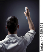 Conceptual picture of a guy pointing spray on a wall. Стоковое фото, агентство Ingram Publishing / Фотобанк Лори
