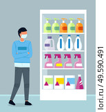 Young hipster wearing face medical mask standing near shelves with detergents in the supermarket. Man keep rules of quarantine during viral pandemic. Guy choose antibacterial agent in shop. Young man wear medical mask standing near shelves with detergents in the supermarket, viral pandemic. Стоковая иллюстрация, агентство Ingram Publishing / Фотобанк Лори
