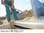 Man filling in grave with sand. Стоковое фото, агентство Ingram Publishing / Фотобанк Лори