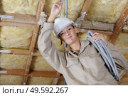 female electrician holding cables indoors. Стоковое фото, агентство Ingram Publishing / Фотобанк Лори