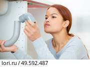 portrait of woman looking at plumbing fittings. Стоковое фото, агентство Ingram Publishing / Фотобанк Лори